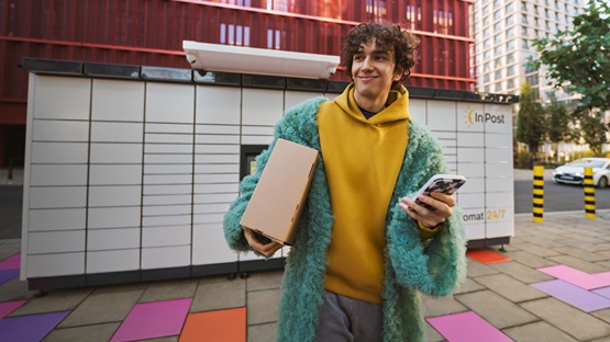 Zadowolona osoba wysyłająca paczkę z Polski za granicę poprzez Paczkomat.