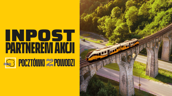 Żółty pociąg przemierza malowniczy wiadukt kolejowy otoczony zielenią. InPost partnerem akcji "Pocztówki z Powodzi".
