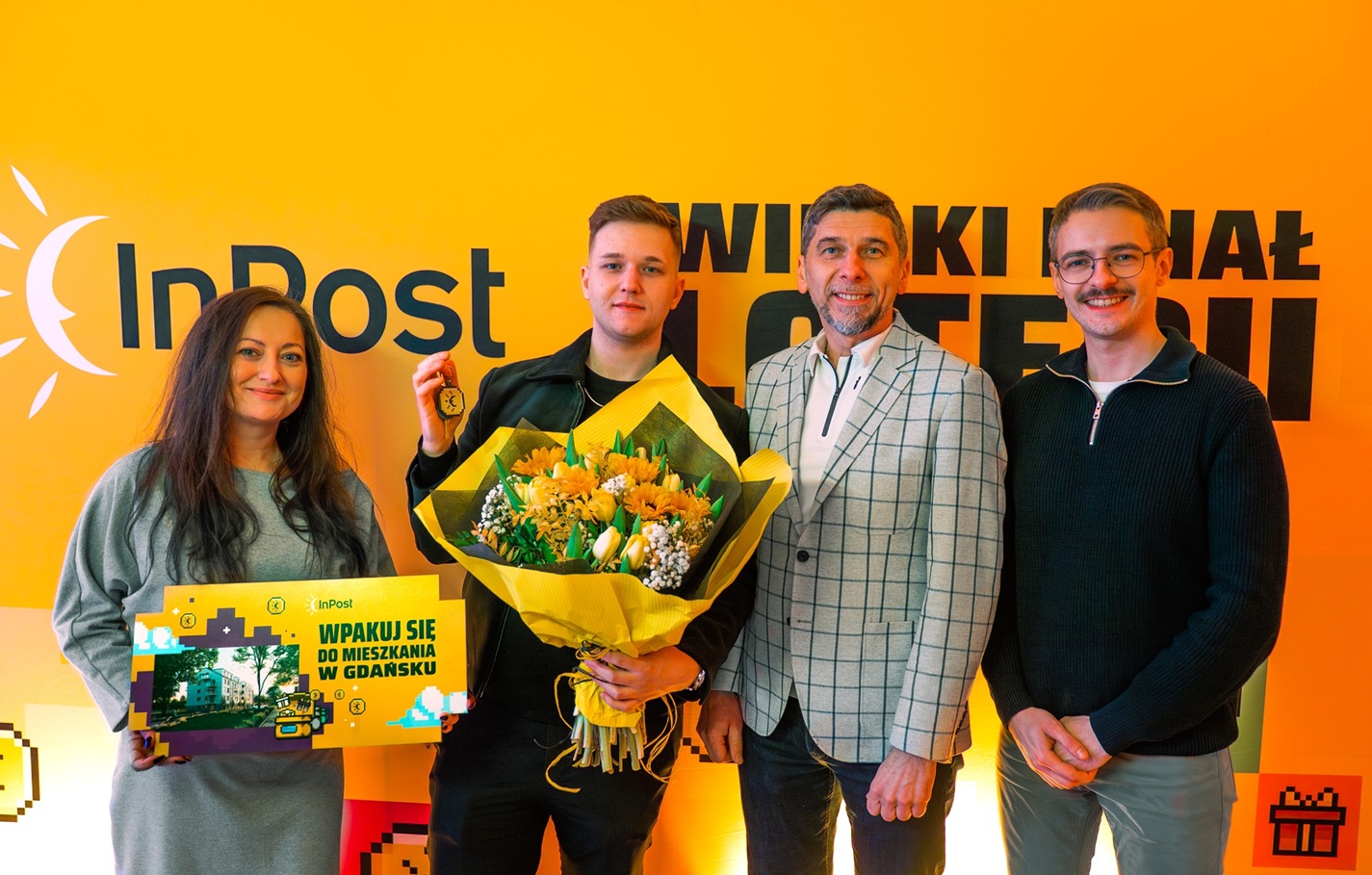 Zwycięzca nagrody pozuje do zdjęcia w towarzystwie Organizatora Loterii