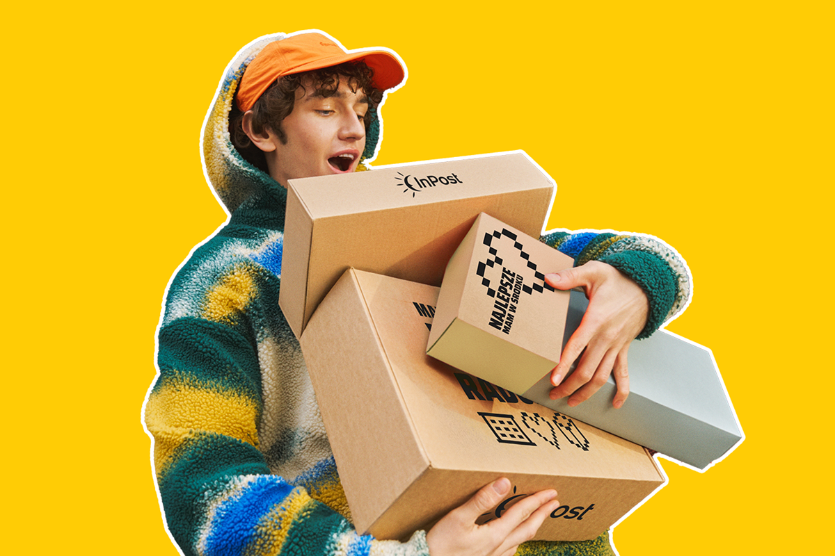 Młody chłopak w czapce z daszkiem niesie kartonowe opakowania z logo InPost i kreatywnymi napisami.